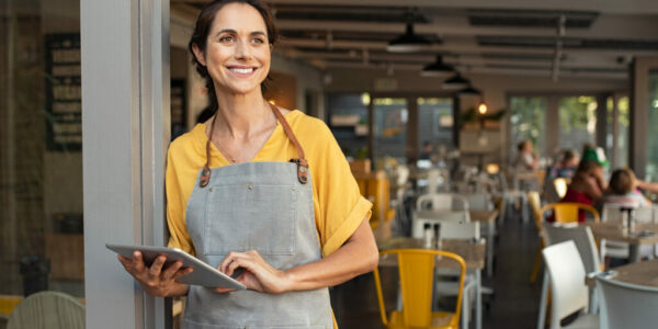 Successful owner standing at cafe entrance