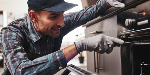 Don't delay with repair. Close-up of repairman examining oven