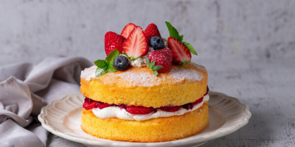 Victoria sandwich cake, decorated with strawberries, blueberries and mint closeup