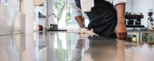 Waiter wiping the counter top in the kitchen