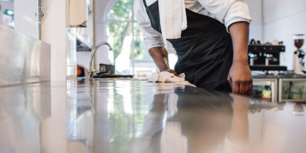 Waiter wiping the counter top in the kitchen