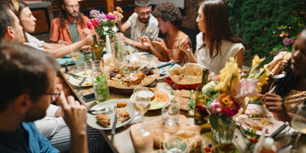 Cheerful friends talking while enjoying dinner at dining table in party