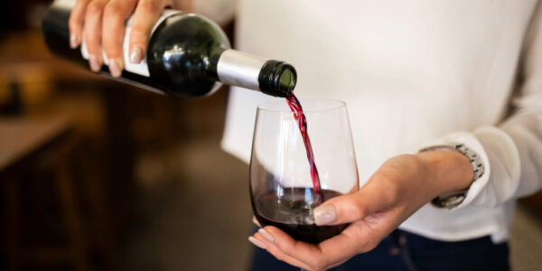 Woman serving red wine in a winery Woman serving red wine in a winery